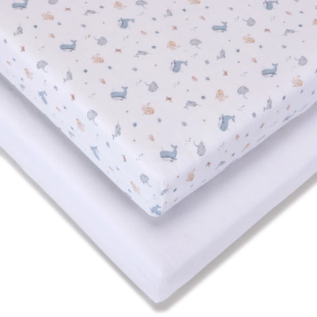 Fitted jersey travel cot sheet with Under the Sea pattern shown over a plain white sheet, highlighting the elasticated corner and layered fabric