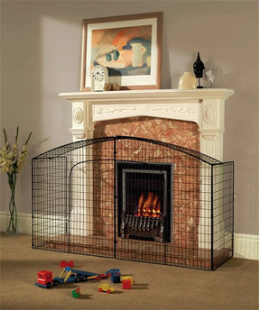Babylo Fireguard Premier black metal fireguard installed around a lit fireplace in a living room with toys on the carpet in front
