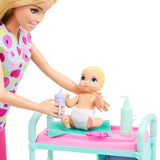 Close-up of Barbie Baby Doctor holding a purple baby bottle beside a blonde baby wearing a white nappy, seated on a turquoise towel on the pink examination table with a mint green pump bottle nearby.