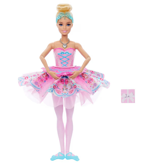 Barbie In The Nutcracker Clara Doll with her hands together over a pink patterned tutu, pale pink tights and blue ballet shoes.