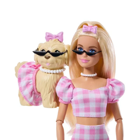 Close-up of Barbie Twinning Looks Doll and pet dog wearing matching sunglasses and bows.