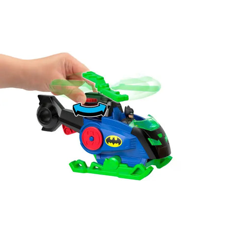 Hand turning the green Batcopter rotor with motion blur and a blue rotation arrow