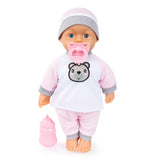 Bayer Kiss Baby Doll standing upright with pink pacifier and bottle beside her on white background