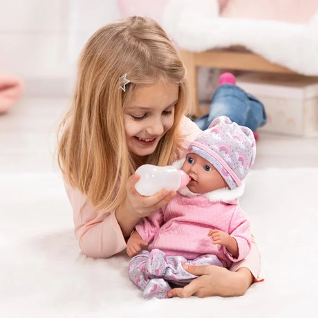 Child holding Bayer Reborn baby doll and feeding it with a bottle