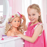 Child brushing Bayer Super Model doll styling head with pink brush at a dressing table