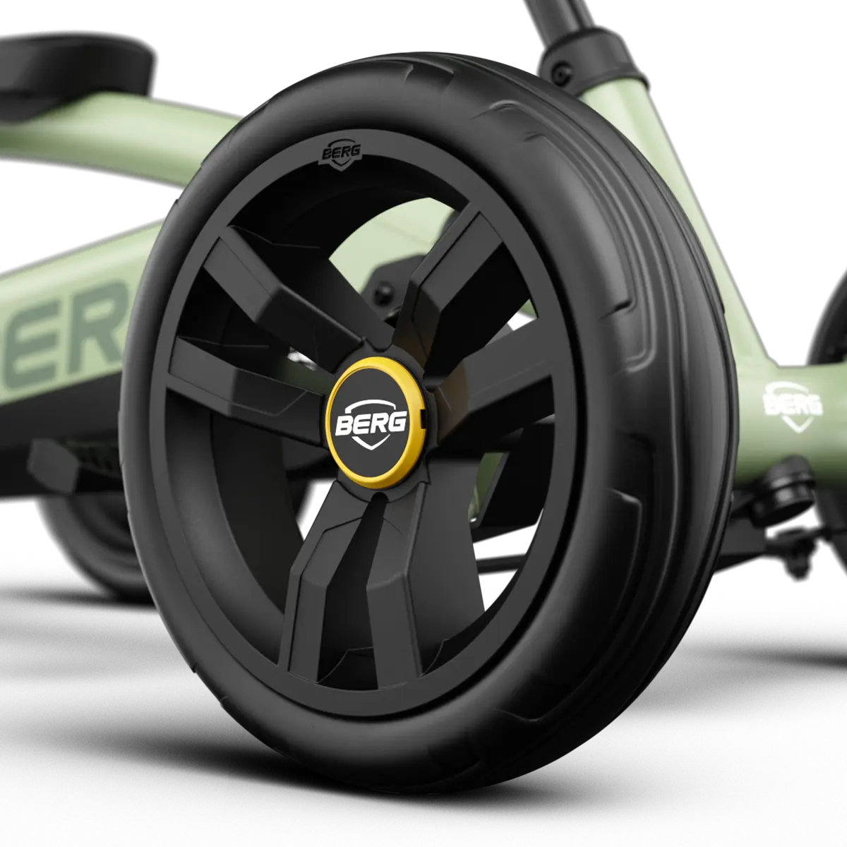 Close-up of the front wheel on the BERG Buzzy Green pedal go-kart with black tyre and BERG wheel badge