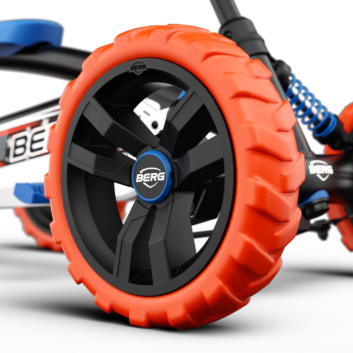 Close-up of orange wheel with black centre and BERG badge on BERG Buzzy Nitro pedal go-kart