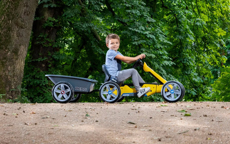 Child towing BERG Trailer M behind yellow BERG Reppy outdoors – Ireland
