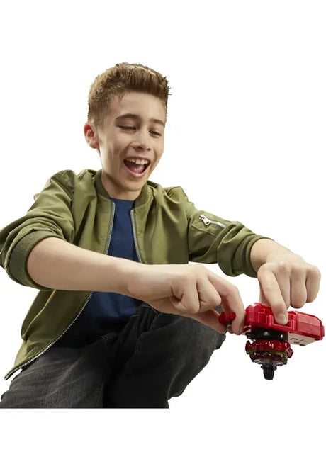 Child using the red Beyblade X Deluxe String Launcher with Soar Phoenix spinning top attached, demonstrating the launch mechanism.