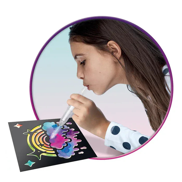 Child using BloPens Tie Dye Style kit to spray rainbow stencil artwork in Ireland