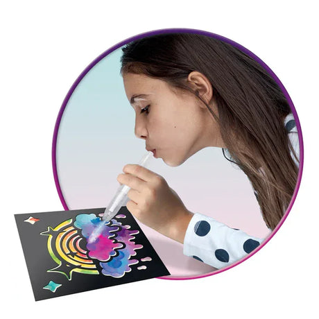 Child using BloPens Tie Dye Style kit to spray rainbow stencil artwork in Ireland