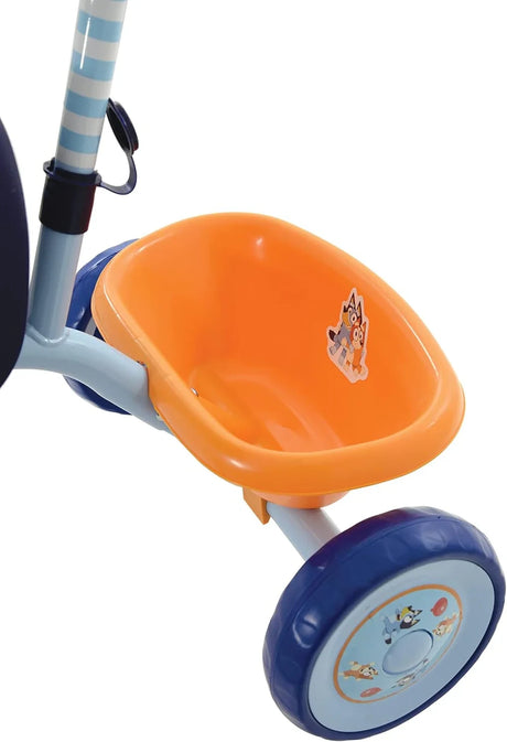 Close up of Bluey My First Trike orange rear bucket, rear wheel, navy seat edge and striped parent handle