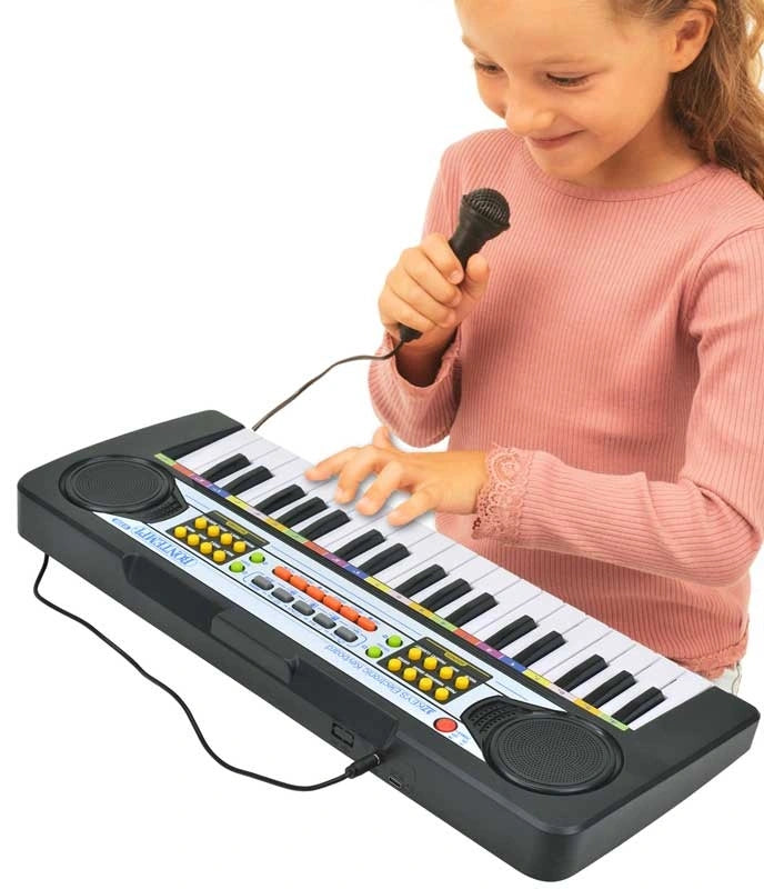 Child playing the Bontempi 37 Key Electronic Keyboard while holding the wired microphone