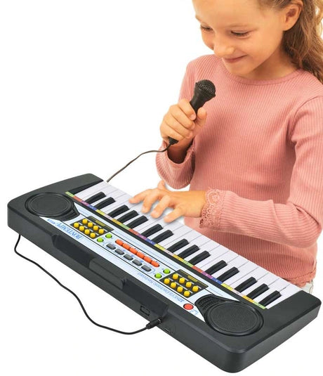 Child playing the Bontempi 37 Key Electronic Keyboard while holding the wired microphone