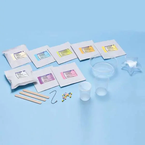 Full contents of Brainstorm Fun With Slime kit including slime powders, mixing pots, sticks and accessories on blue surface