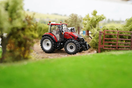 Britains Case Farmall 120 C farm toy tractor shown side on beside a model lane