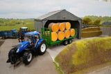 Britains 1:32 Flat Bed Trailer loaded with round bales behind blue tractor in farmyard scene