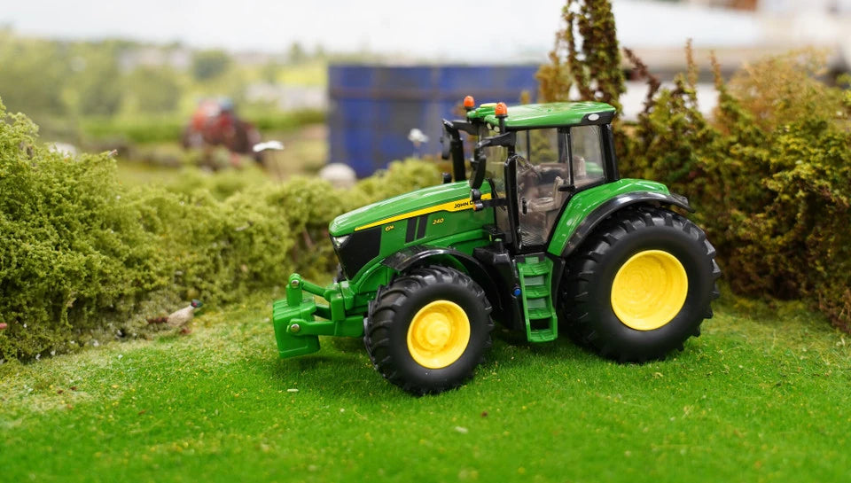 Britains John Deere 6M 240 farm toy tractor shown side on in a grass model farm layout