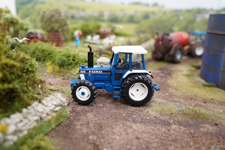 Britains 1:32 Ford 8210 Tractor 43418 positioned on a model farm track with farm machinery in the background