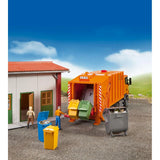 Bruder 02607 refuse bins in a waste collection scene featuring an orange garbage truck loading yellow and green bins, with a blue bin and grey container nearby.