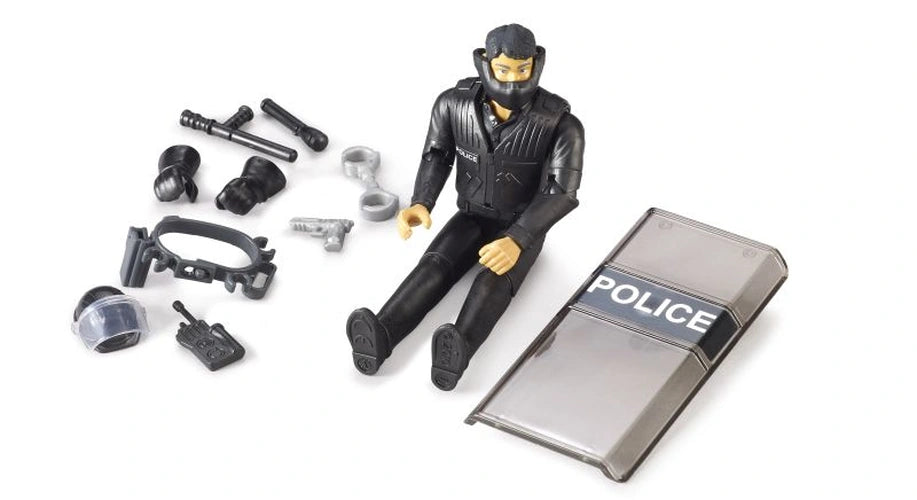 Bruder bworld Special Forces Police Officer 62151 seated beside a transparent POLICE shield, helmet visor, handcuffs, baton and removable police equipment.
