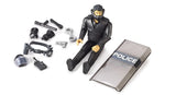 Bruder bworld Special Forces Police Officer 62151 seated beside a transparent POLICE shield, helmet visor, handcuffs, baton and removable police equipment.