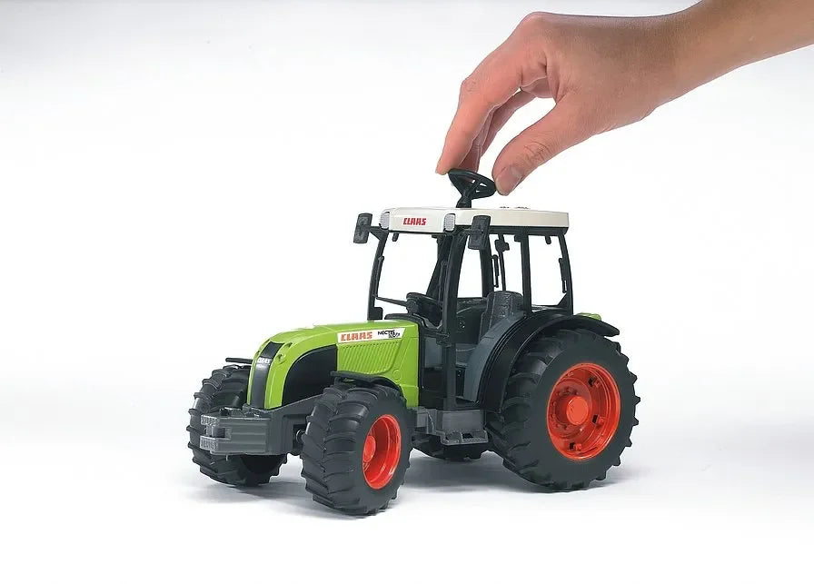 A Claas Nectis 267F toy tractor being steered through the roof using a hand operated control.
