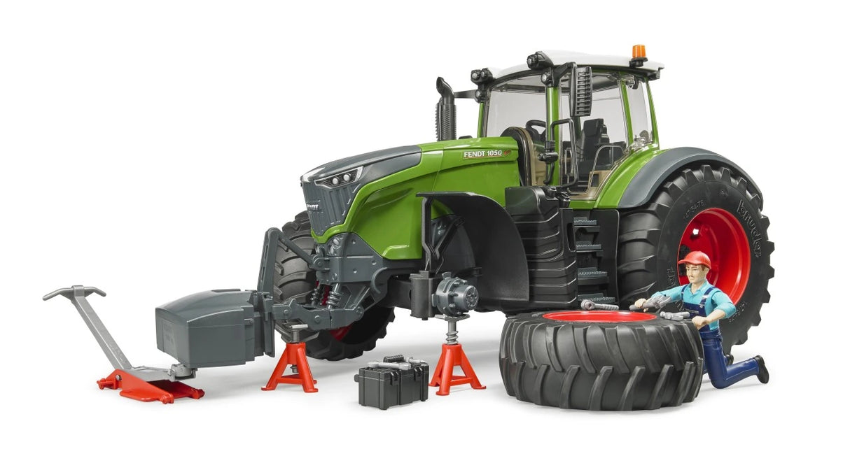 Bruder Fendt 1050 Vario with front wheel removed, mechanic kneeling beside the tyre, jack, axle stands and toolbox
