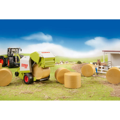 A toy Claas round baler on a grass field beside six ochre brown round hay bales and other farm toys.