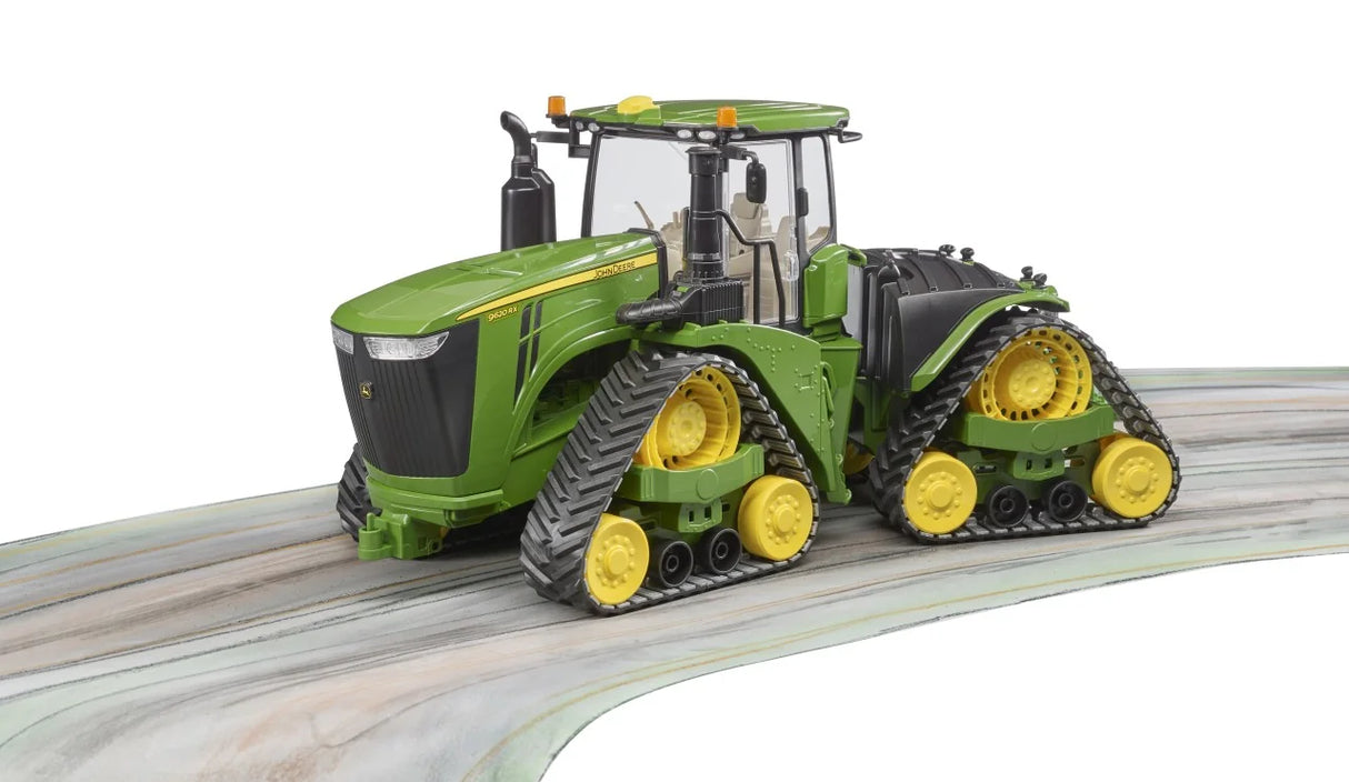John Deere 9620RX tractor toy positioned on a curved surface showing crawler tracks and enclosed cab