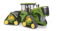John Deere 9620RX tractor toy in green and yellow with enclosed cab, open engine hood, and four crawler track units on a white background