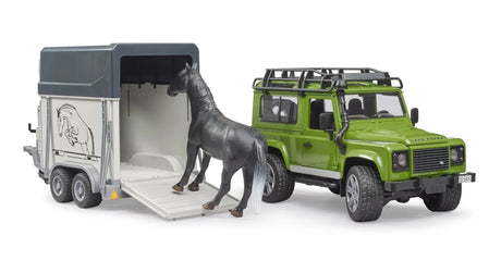 Bruder 1:16 Land Rover Defender farm toy with horse trailer ramp lowered and horse loading into the trailer