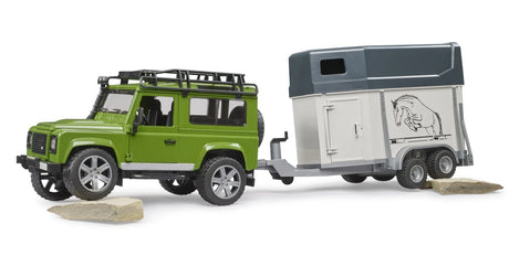 Bruder 1:16 Land Rover Defender farm toy towing the horse trailer over uneven ground