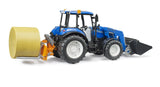 Blue farm toy tractor carrying a round bale on rear forks