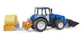 Blue farm toy tractor with rear bale attachment, forks and round bale