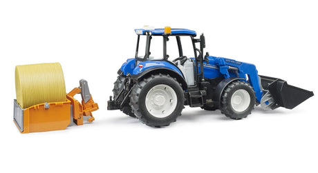 Side view of blue farm toy tractor beside rear bale attachment and round bale