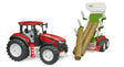 Red Roadmax tractor beside a green forestry trailer tipped upward with three brown tree trunk pieces sliding from the load bed on a white background.
