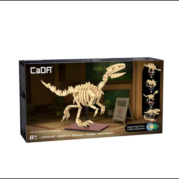 CaDA Dinosaur Fossils Velociraptor box and model showing tan skeletal figure on brown base with open jaw pose