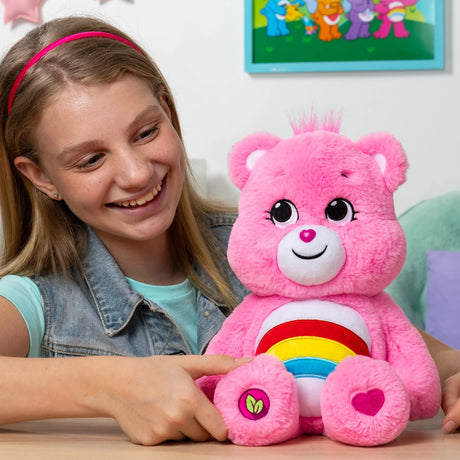 Child playing with Care Bears Cheer Bear eco-friendly 14″ plush toy with rainbow belly badge in Ireland.