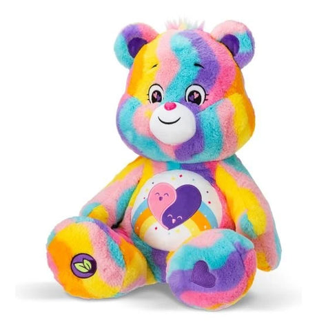 Care Bears Jumbo Plush Friends Forever Bear seated three-quarter view showing multicolour striped fur, double heart tummy badge, leaf foot detail and heart embroidery on foot