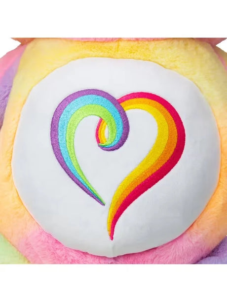 Close-up of the Care Bears Togetherness Bear embroidered tummy badge showing a multicolour rainbow swirl heart on white plush
