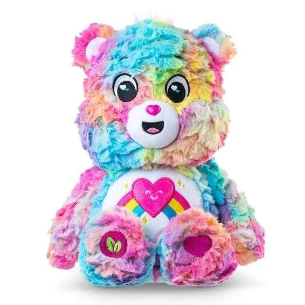 Care Bears Colours of Caring Bear medium plush seated front view, showing multicolour rainbow fur, embroidered face, heart and rainbow tummy badge and leaf detail on foot