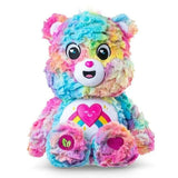 Care Bears Colours of Caring Bear medium plush seated front view, showing multicolour rainbow fur, embroidered face, heart and rainbow tummy badge and leaf detail on foot