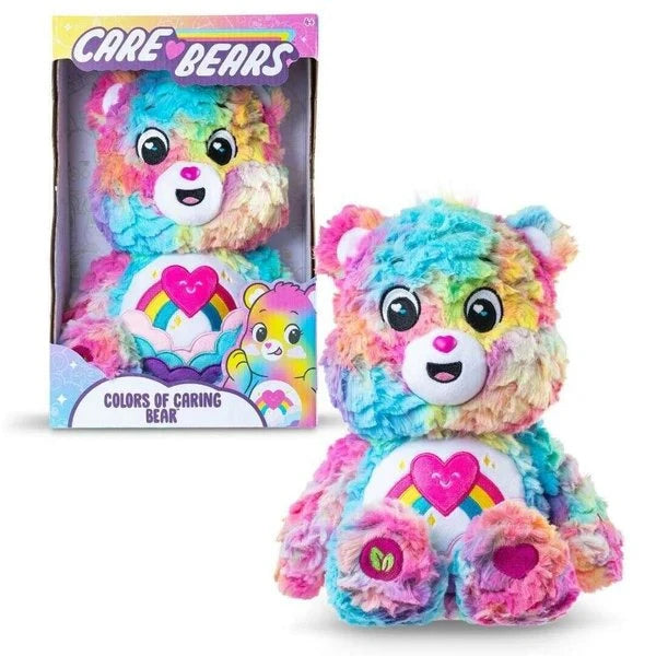 Care Bears Colours of Caring Bear medium plush shown beside its retail box, displaying the rainbow multicolour fur, heart and rainbow tummy badge and Care Bears branding