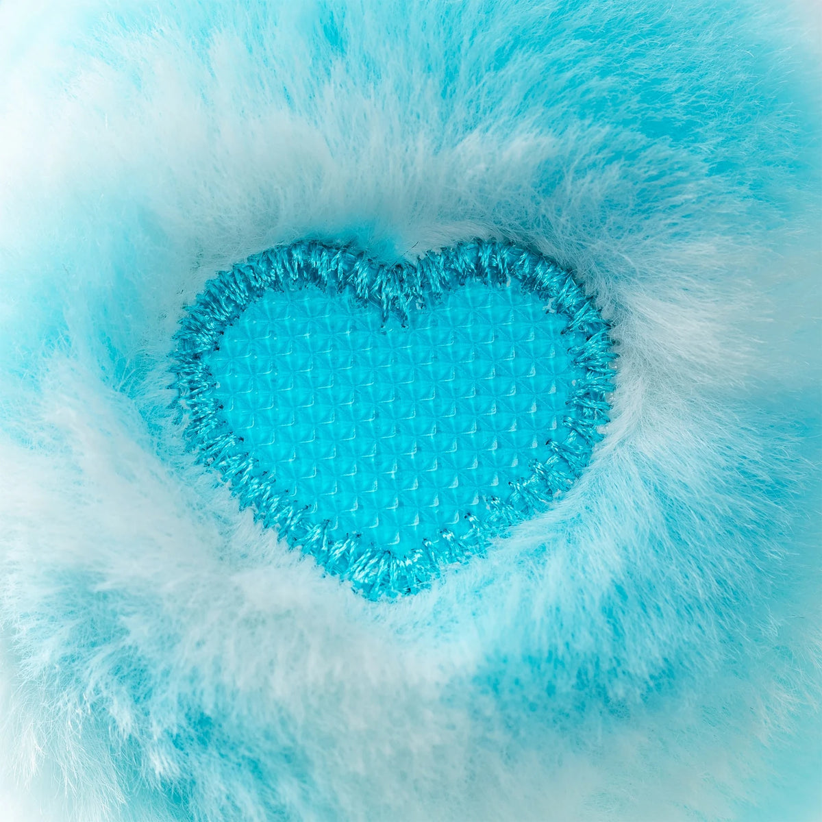 Close-up of Sweet Serenity Bear's turquoise heart shaped textured paw pad surrounded by soft blue plush fur, showing the raised sensory surface.