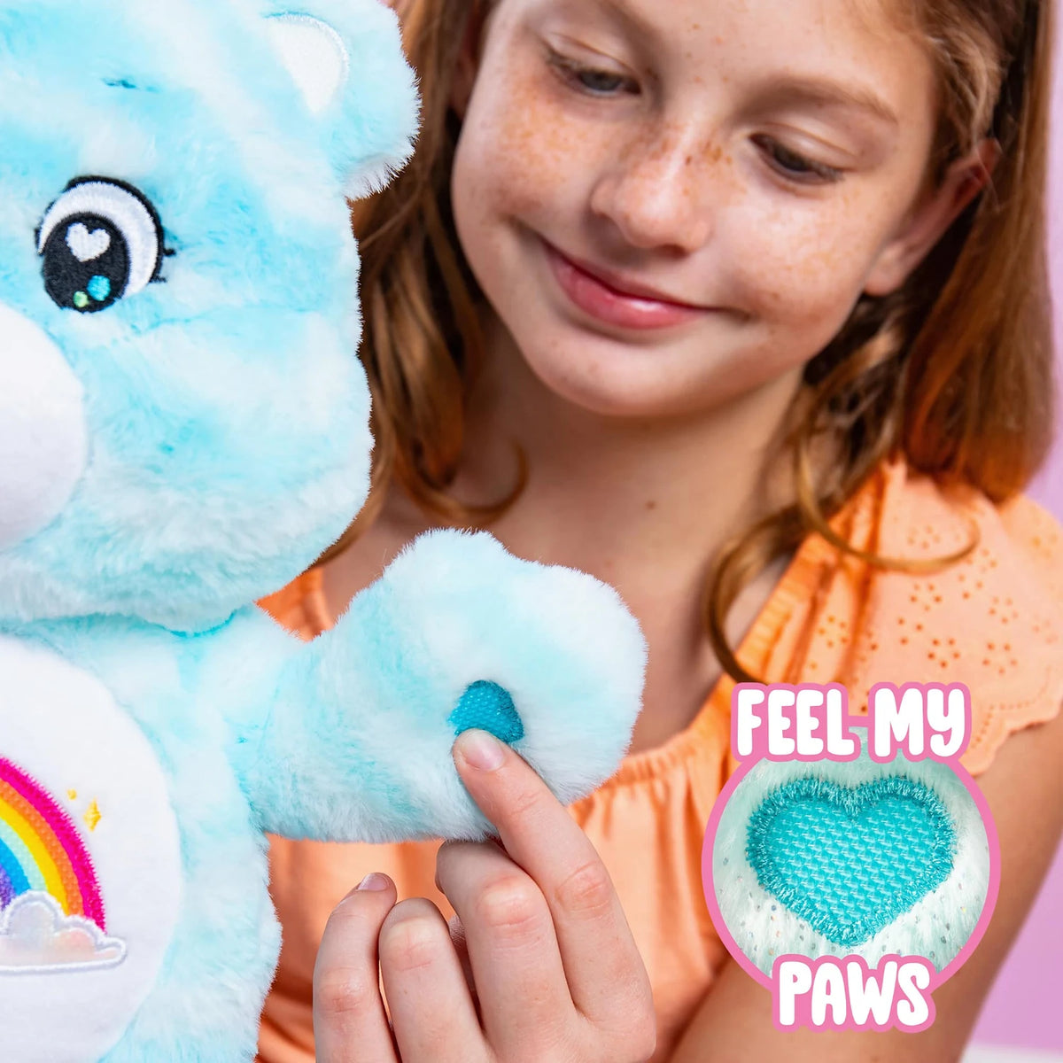 Child touching Sweet Serenity Bear's textured turquoise heart paw pad, with a close-up inset highlighting the sensory fabric on the blue plush bear.