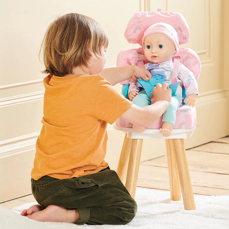 Casdon Baby Huggles Booster Seat with doll seated in the pink rainbow print seat and child adjusting the harness