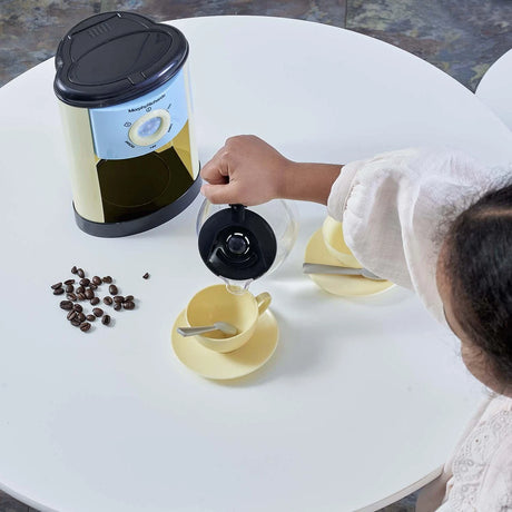 Child using the coffee maker from the Casdon Morphy Richards Kitchen Set with cups and pretend coffee beans