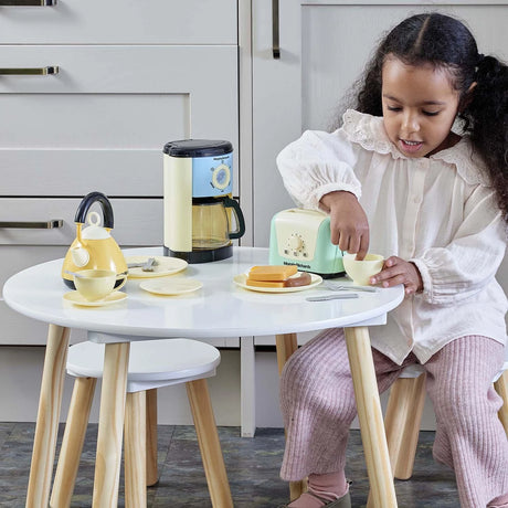Child using the toaster from the Casdon Morphy Richards Kitchen Set beside the kettle, coffee maker, cups and plates
