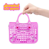 Hand holding a bright pink Cha Cha Cha purse with top handles, a lattice front and zip detail.